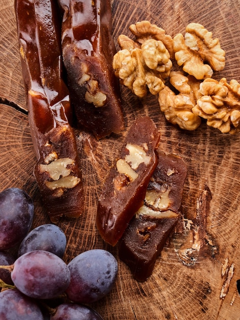 Churchkhela, national Georgian dessert made from grape juice and walnuts, composition on a wooden table