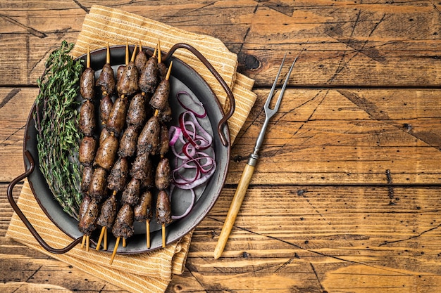 Photo churrasco brazilian barbecue chicken hearts grilled kebabs with herbs and vegetables wooden background top view copy space