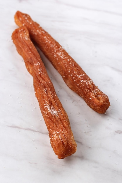 Churro stick con zucchero spinkle, isolato su sfondo bianco con copia spazio. concetto di panetteria bianca, per testo o ricetta