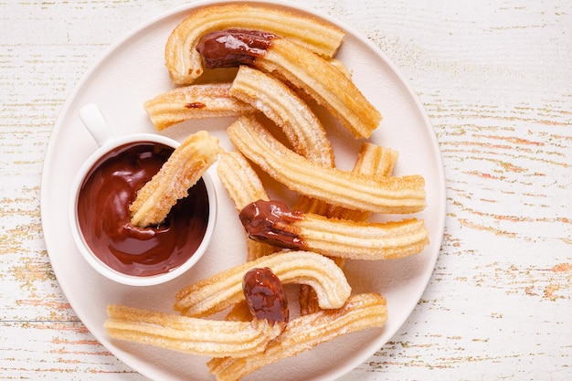 Churros met poedersuiker en chocoladesaus bovenaanzicht