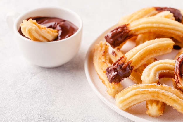 Churros met poedersuiker en chocoladesaus.