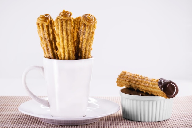 churros in a mug traditional fried sweet from Latin America Brazil Colombia United States and Portugal served with or without filling sprinkled with sugar copy space