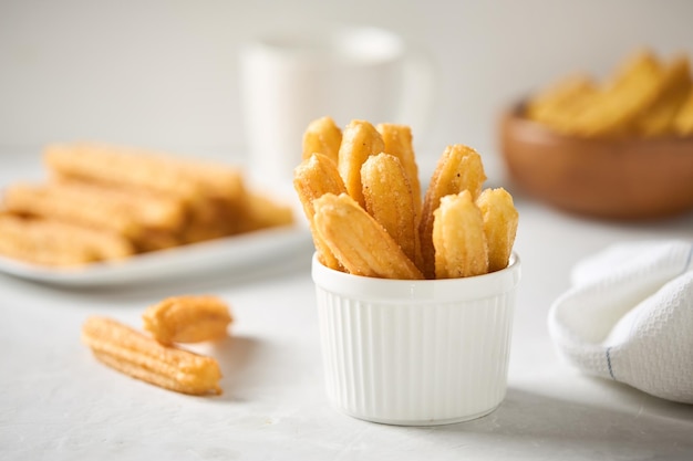 Churros with sugar and cinnamon on a light background Traditional Spanish street fast food Homemade baking