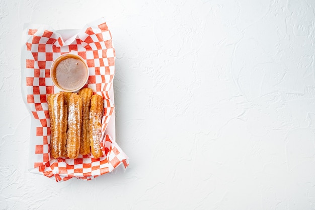 Churros with sugar powder, in the box  in paper tray, on white background, top view flat lay with space for text, copyspace