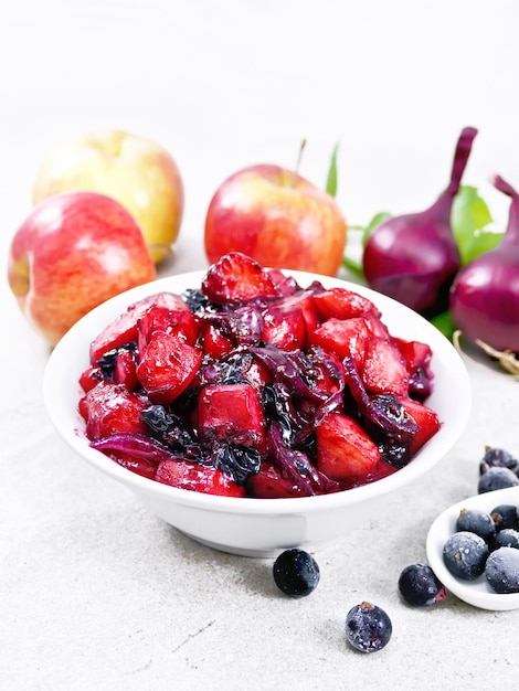 Chutney of apple and blackcurrant in bowl on gray granite