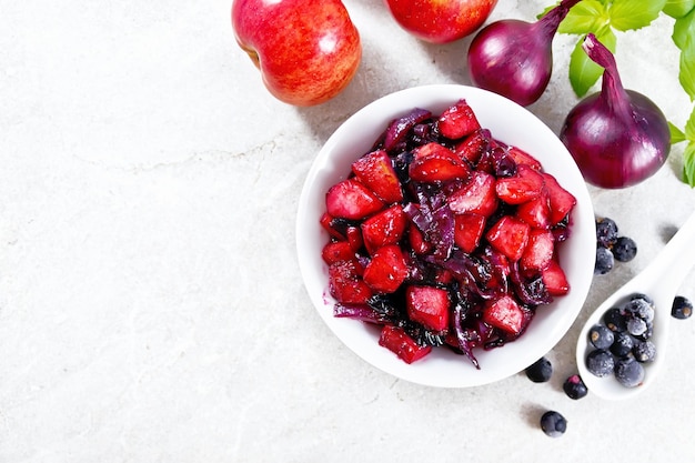 Chutney of apple and blackcurrant in bowl on table top