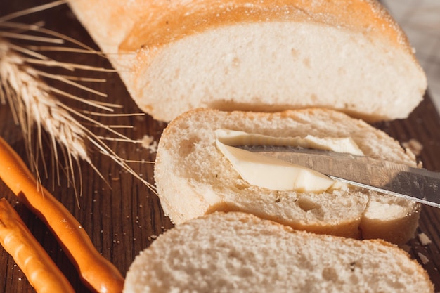 Ciabatta bread with ears of wheat. Spread butter on bread.