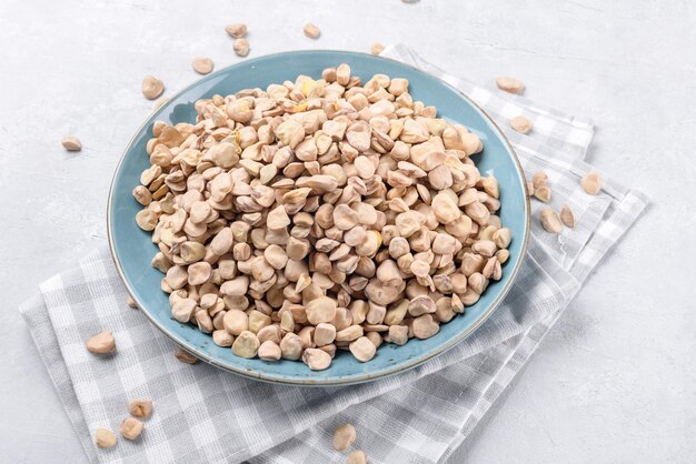 Photo cicerchia or indian pea on plate on grey table background gluten free food legumes made in puglia
