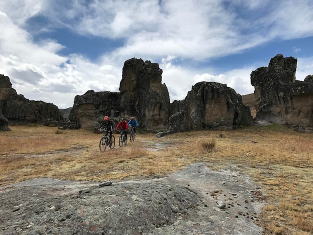 Ciclistas en la llanura por un camino estreno entre rocas