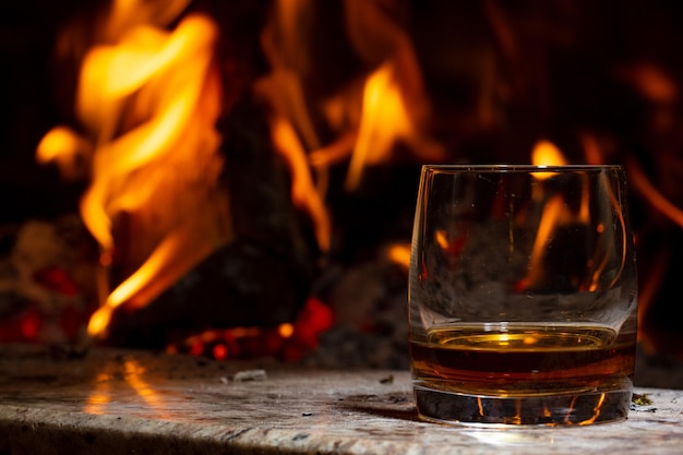 Cigar and a glass of cognac on the background of the fireplace