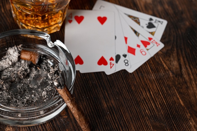 Cigar and playing cards on casino table