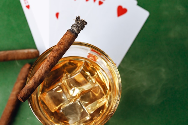 Cigar and playing cards on casino table