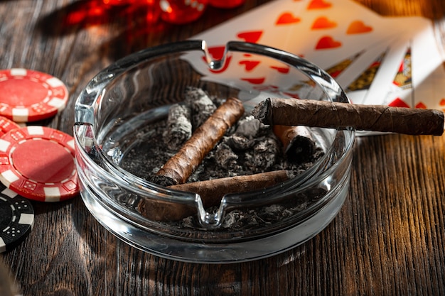 Cigar and playing cards on casino table