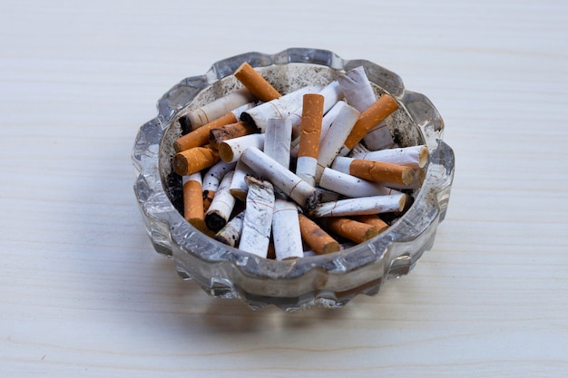 Cigarette butts in glass ashtray