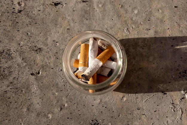 Cigarette butts in a glass jar Smoking concept