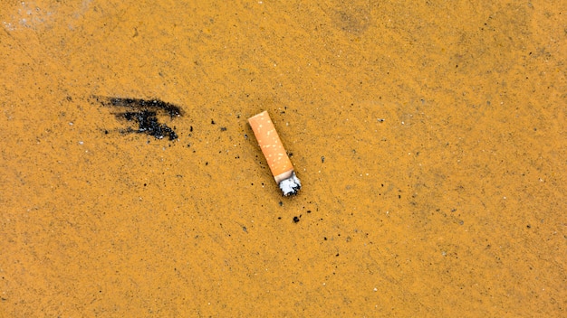 더러운 노란 바닥에 담배 스텁