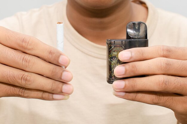 Cigarette vs e-cigarette concept. man holding cigarette and vape.