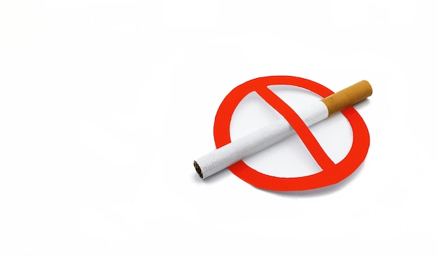 A cigarette without a trademark next to a red forbidden sign on white background no smoking