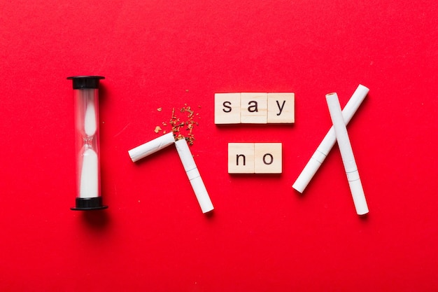 Cigarette And Wooden Blocks Broken cigarette on table background with hourglass No Tobacco Day with hourglass clock health concept time to quit smoking