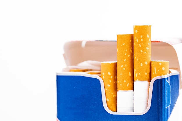 Cigarettes in a pack closeup on white background. Smoking tobacco. Bad habit.