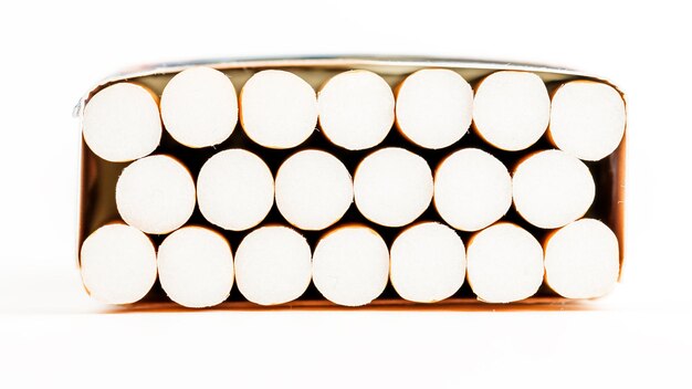 Cigarettes in a pack closeup on white background Smoking tobacco Bad habit