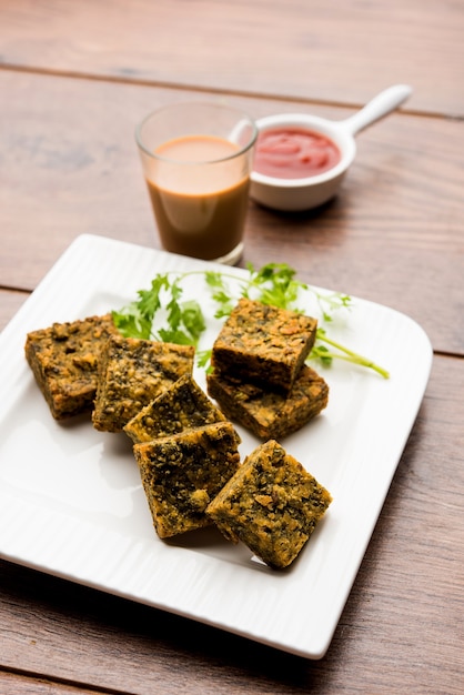 Cilantro cake or Kothimbir Vadi is a popular maharashtrian cuisine made with cilantro leaves. served with tomato ketchup. selective focus