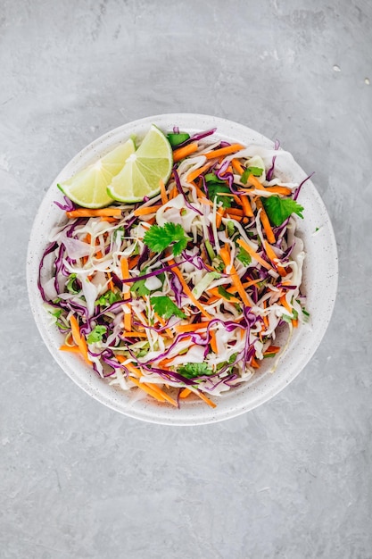 Cilantro-limoenkoolsalade met rode en witte kool op grijze steenachtergrond