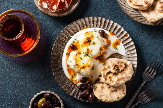 Cilbir or Turkish Eggs mezze poached eggs topped over herbed greek yogurt then drizzled with hot spiced paprika olive oil Traditional Turkish breakfast with rahat