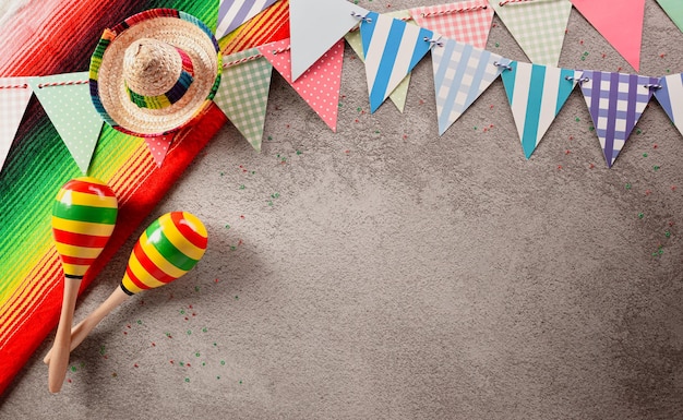 Cinco de Mayo holiday background made from maracas and hat on dark stone background