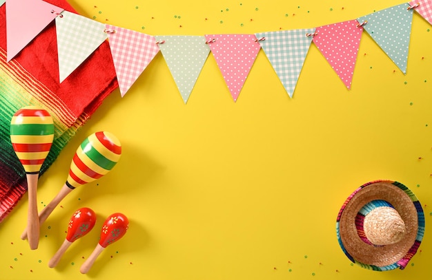 Foto sfondo vacanza cinco de mayo realizzato con maracas e cappello su sfondo giallo