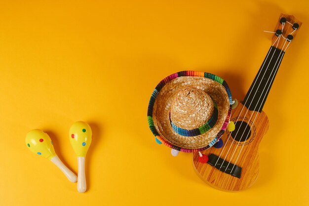 Foto cinco de mayo sfondo festivo maracas cappello messicano e chitarra su sfondo arancione