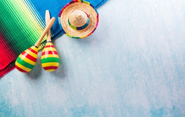 Cinco de Mayo vakantie achtergrond gemaakt van maracas Mexicaanse deken strepen of poncho serape en hoed op blauwe achtergrond