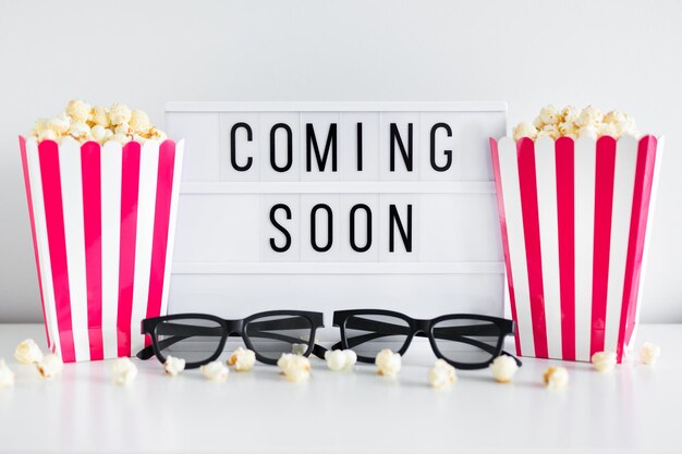 Photo cinema concept - red striped boxes with popcorn, 3d glasses and light box with 