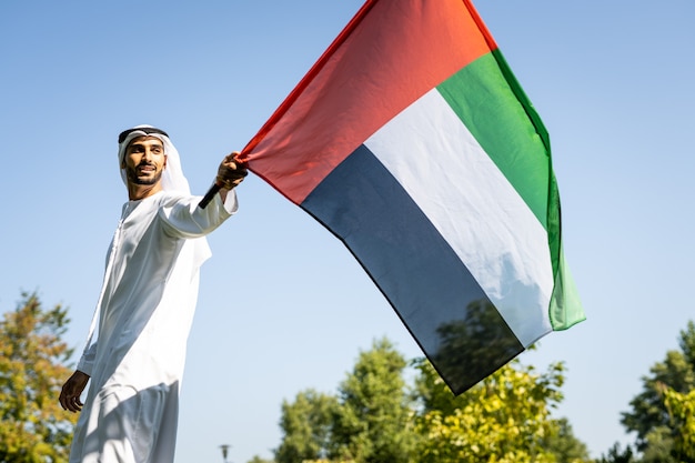 Immagine cinematografica di una famiglia degli emirati che trascorre del tempo al parco. giovane che gioca a calcio nell'erba