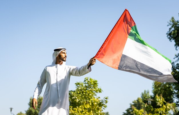 Immagine cinematografica di una famiglia degli emirati che trascorre del tempo al parco. giovane che gioca a calcio nell'erba