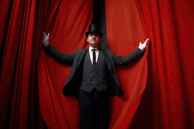 사진 빨간 벨 무대 커튼 위에 마술사 배우의 영화적 포즈 초상화