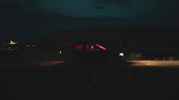 Photo cinematic scene of a man driving a car with a castle behind at dusk interior illuminated with red light