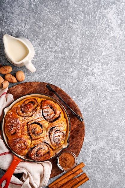 Cinnabon cinnamon rolls buns with pumpkin, nut, caramel and sugar cream iced. Top view. Sweet Homemade Pastry christmas baking. Close-up. Kanelbule - swedish dessert.