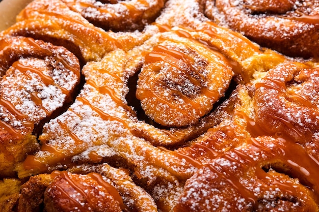 Cinnabon kaneelbroodjes met pompoen, noten, karamel en suikerroomijs. Textuur. Zachte en selectieve focus. Kanelbule - Zweeds dessert.