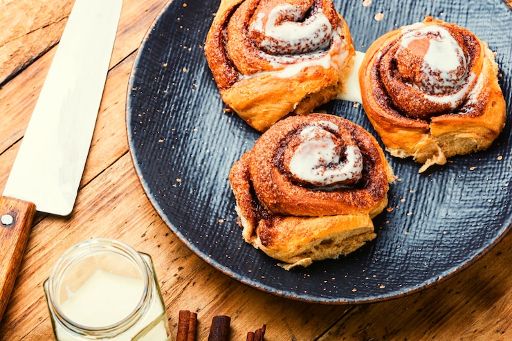 Photo cinnabones with cinnamon and mascarpone cheese.homemade buns on a plate.cinnamon rolls or cinnabon