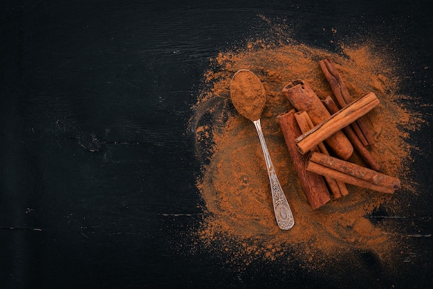 Cinnamon on a black wooden background Free space for text Top view