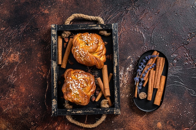 Cinnamon buns or rolls, Swedish Kanelbullar. Dark background. Top view.