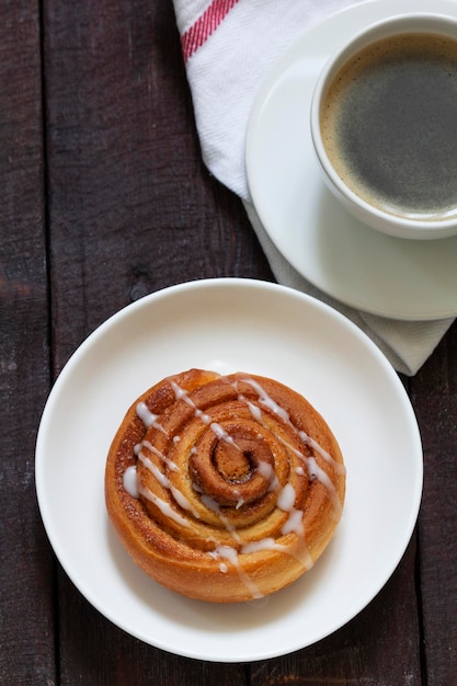 Photo cinnamon buns with icing served with coffee rustic style