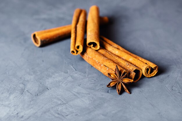 Cinnamon and cloves on grey table.