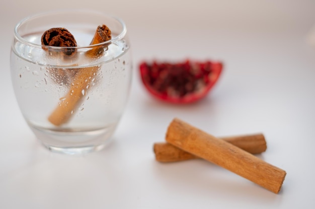 Photo cinnamon cups and pomegranate on a white background.