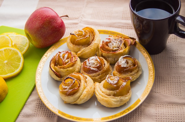 Cinnamon rolls, Apple on the plate. Tea Cup and lemon