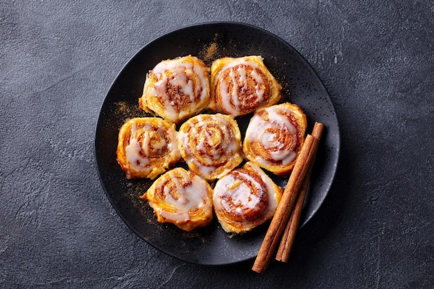 Cinnamon rolls on black plate Dark background Close up Top view