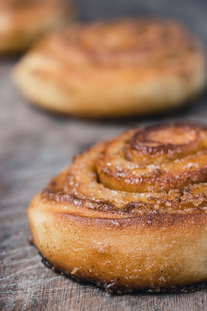 Cinnamon rolls on old wooden background