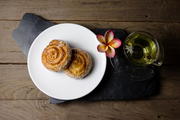 Cinnamon rolls with Chrysanthemum tea on wood background