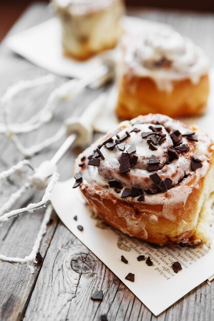 Cinnamon rolls with cream cheese and chocolate chips  on wooden